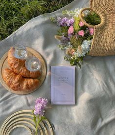 the table is set with flowers and croissants