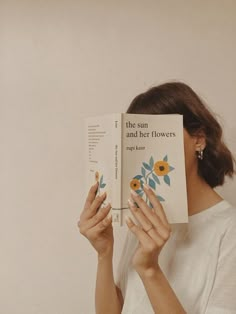 a woman reading a book about the sun and her flowers, in front of a white background