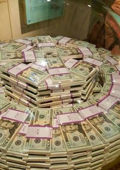 stacks of money sitting on top of each other in front of a glass display case