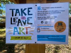 a sign that says take leave art free on the side of a wooden post in front of some trees