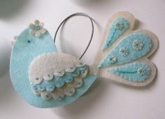 a blue and white bird ornament hanging from a hook on a table with other items