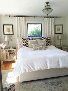 a white bed sitting under a window in a bedroom