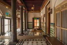 an ornate hallway with columns and tiled floors