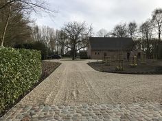 a gravel driveway leading to a house in the distance