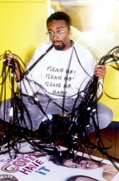 a man sitting on the floor surrounded by wires in front of his face and hands