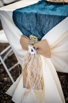 a blue and white table cloth with burlock tied around it, sitting on top of a chair