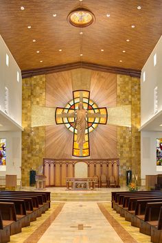 the inside of a church with stained glass windows and wooden pews on both sides