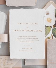 the wedding stationery is laid out on top of each other