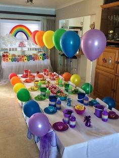 the table is set up with balloons and candy