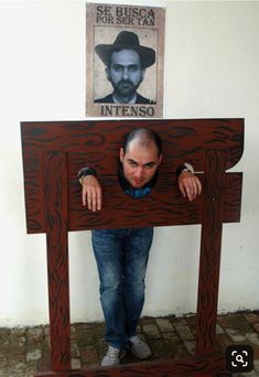 a man is hiding under a wooden table