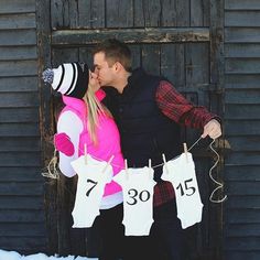 a man and woman standing next to each other in front of a barn door with clothes hanging from the line