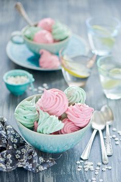 two bowls filled with cupcakes on top of a table next to silverware