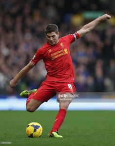 a man kicking a soccer ball on top of a field