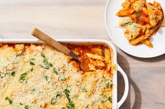 a casserole dish with pasta and cheese on the side next to a plate of chicken parmesan