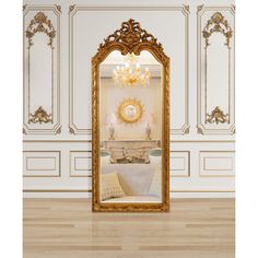 an ornate gold framed mirror in the middle of a room with white walls and wood flooring