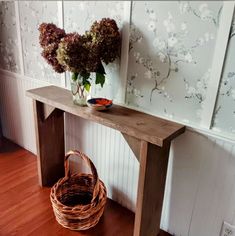 a wooden table with a basket and flowers on it