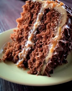 a piece of chocolate cake on a yellow plate with white frosting and caramel drizzle