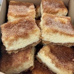 several pieces of cake in a box with powdered sugar toppings on top, sitting next to each other