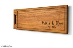 a wooden plaque with the name and date engraved on it's side, hanging on a wall