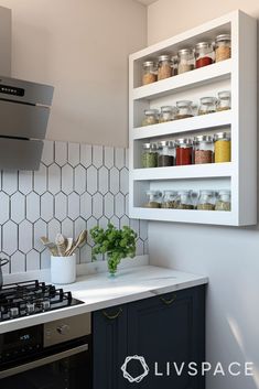 a kitchen with white hexagonal tiles on the wall and shelves above the stove