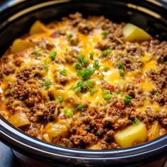 a crock pot filled with ground beef and potato casserole, garnished with parsley