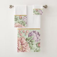 two towels hanging on a towel rack with flowers and leaves painted on them in pastel colors