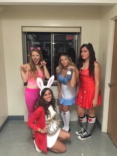 four girls dressed up in costumes posing for the camera