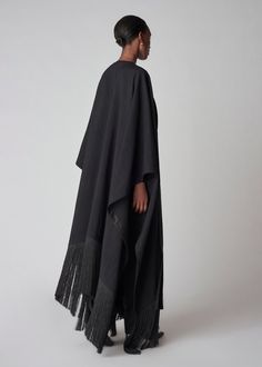 Full length dramatic woven cape trimmed with black fringe. Fused lining. One size. Details 100% Viscose Black 9163RBV-F24 One size Approx 28" in length (front) 33" length (back Model is 5'10" Italian Nature, Long Poncho, Fringe Coat, Nature Witch, Fringe Coats, Instagram Editor, Back Model, Fringe Shawl, Exclusive Dress