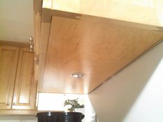 a stove top oven sitting inside of a kitchen next to wooden cabinets and counter tops