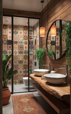 a bathroom with two sinks, mirrors and plants in the corner on either side of the sink