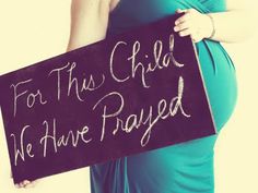 a pregnant woman holding a sign that says for this child we have played