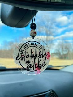 the inside of a car with graffiti written on it's side window and hanging from the dash board