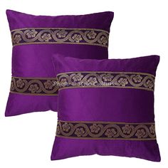 two purple pillows with gold trim on them