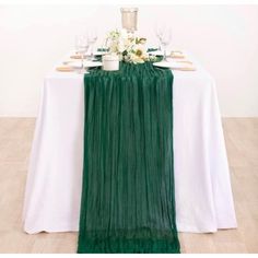 the table is set with white and green linens