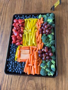 a tray filled with fruits and vegetables on top of a wooden table