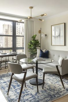 a living room filled with furniture and a large window covered in lots of windows next to a table