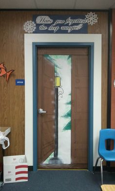 an office door is open in front of a blue chair and wooden wall with snowflakes on it