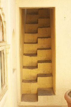 the stairs are made out of concrete and cement blocks, in front of a window