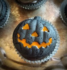 a cupcake decorated like a jack - o'- lantern