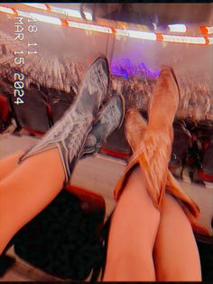 the legs and feet of a person sitting in front of an audience at a sporting event