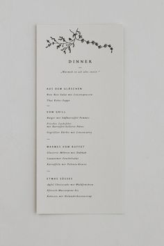 a white menu card with black ink on it and the word dinner written in cursive writing