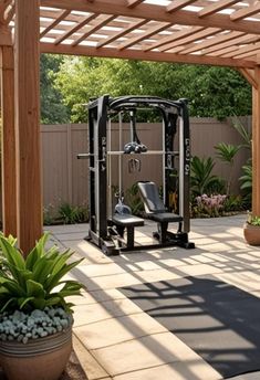 an outdoor gym is shown in the middle of a patio area with potted plants