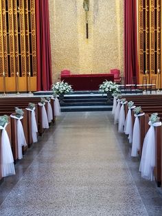 an empty church with pews and flower arrangements