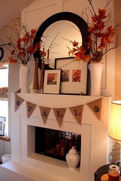 a mantle decorated with fall decorations and pictures