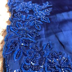 an image of blue fabric with beading on the bottom and side, in close up