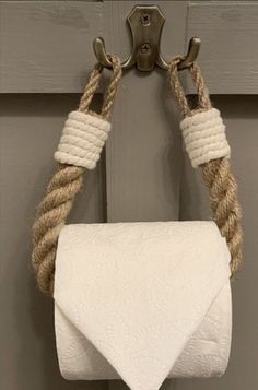 a white towel hanging from a metal hook on a door with rope wrapped around it