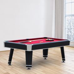 a pool table in the middle of a living room with hardwood floors and white walls