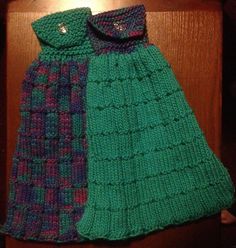 two knitted scarves sitting on top of a wooden table