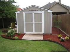 a backyard with a shed and flower bed