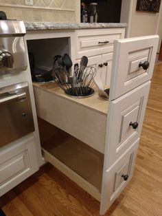 an open drawer in the middle of a kitchen